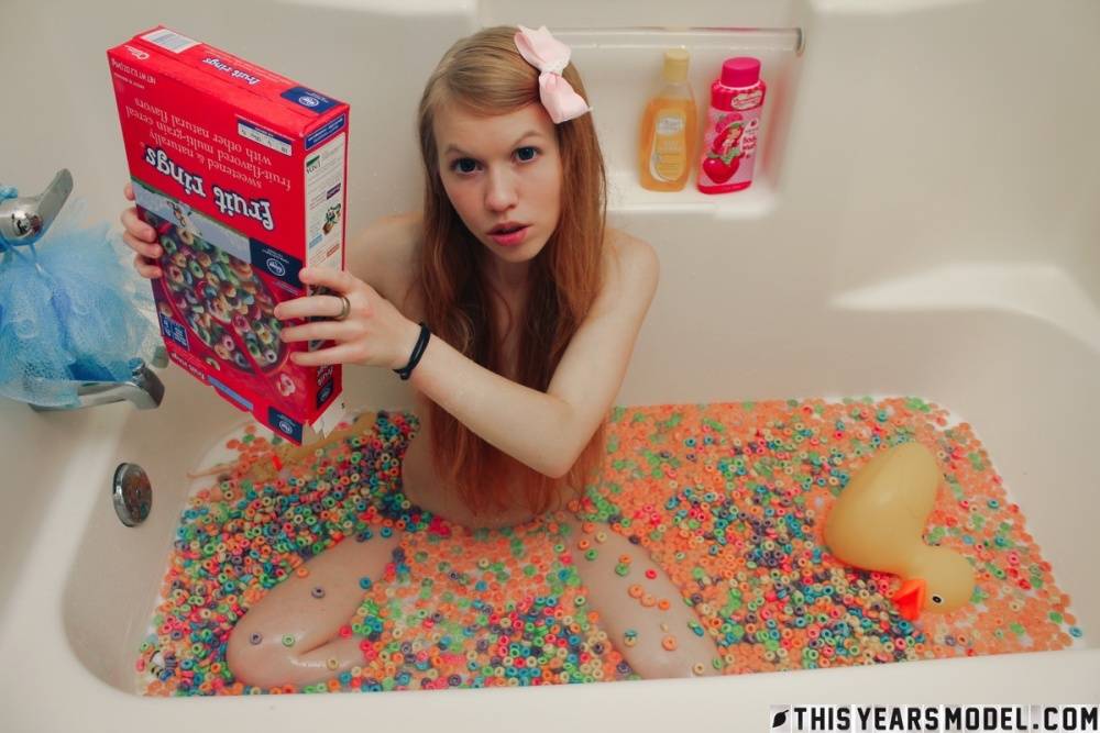 Young looking girl Dolly Little empties a box of cereal into her bathwater - #3