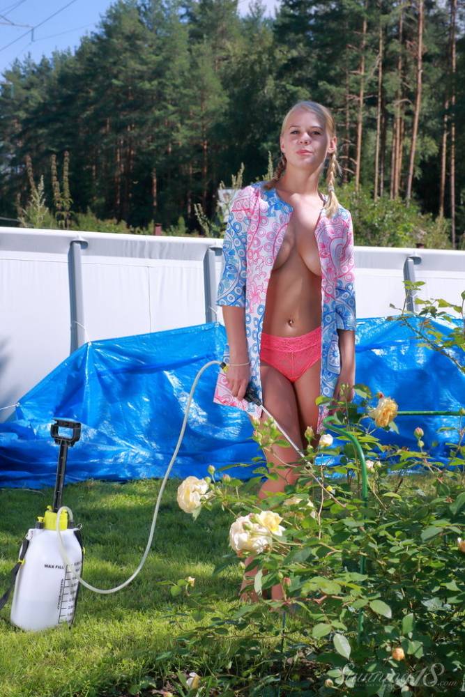 Young blonde Darina N displays her full breasts while getting naked in a yard - #7