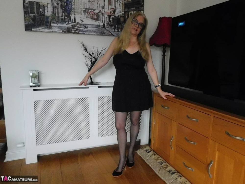 British woman Lily May uncovers her large breasts near a big screen TV | Photo: 569575