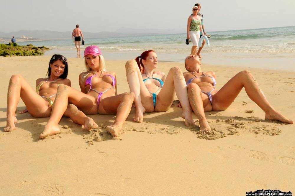 Four girls take off their bikinis to model naked on a public beach - #1