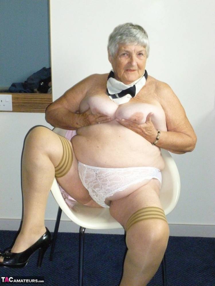 Obese old woman Grandma Libby lays her floppy tits on a desk while undressing - #1