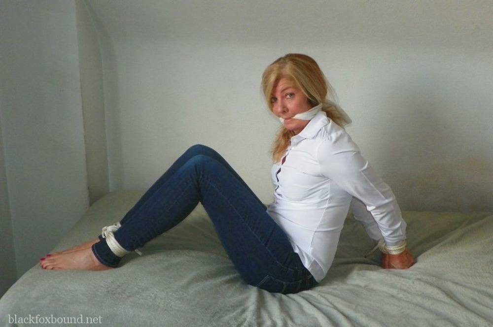 Blonde woman is cleave gagged and hogtied in a white blouse and blue jeans - #16