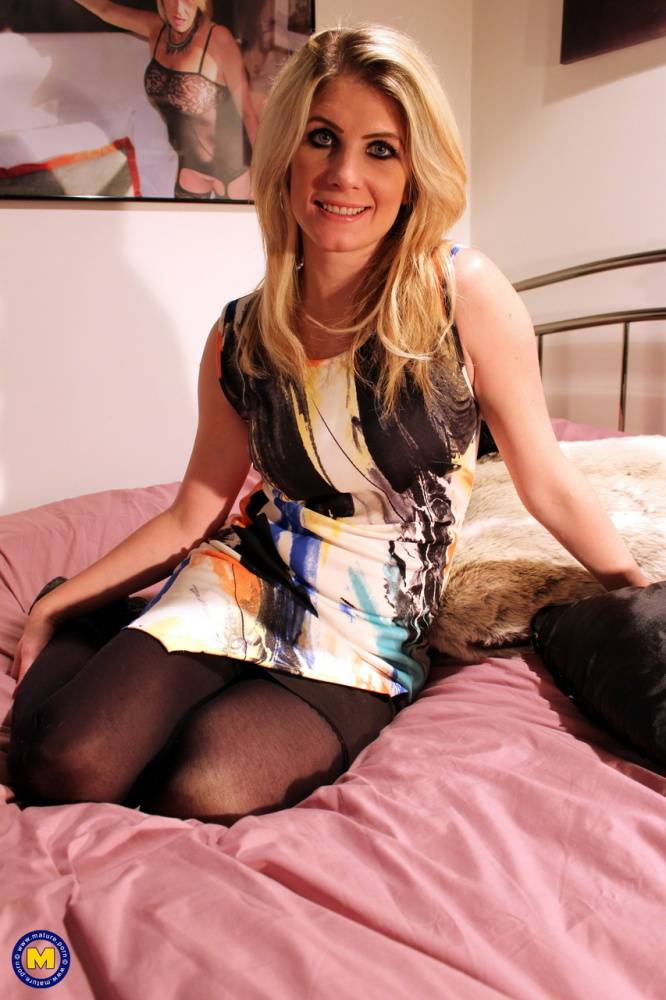 British woman with dirty blonde hair rolls off her stockings on top her bed - #11