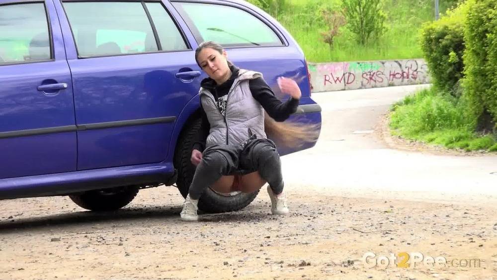 White girl Lara Fox squats for an urgent piss behind an automobile - #11