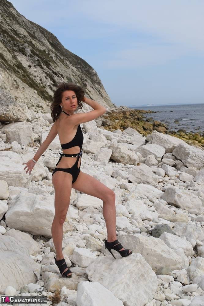 Amateur model poses in a rocky location while wearing a bathing suit and heels | Photo: 1136071