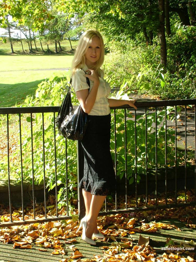 Clothed blonde Iona shows off her white stilettos in a long skirt by a park - #3