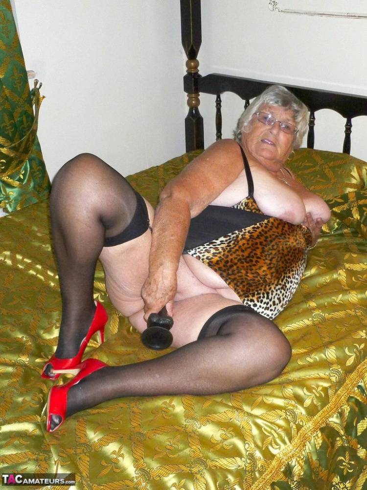 Old amateur Grandma Libby takes a big black dildo to her snatch on a bed | Photo: 1278449