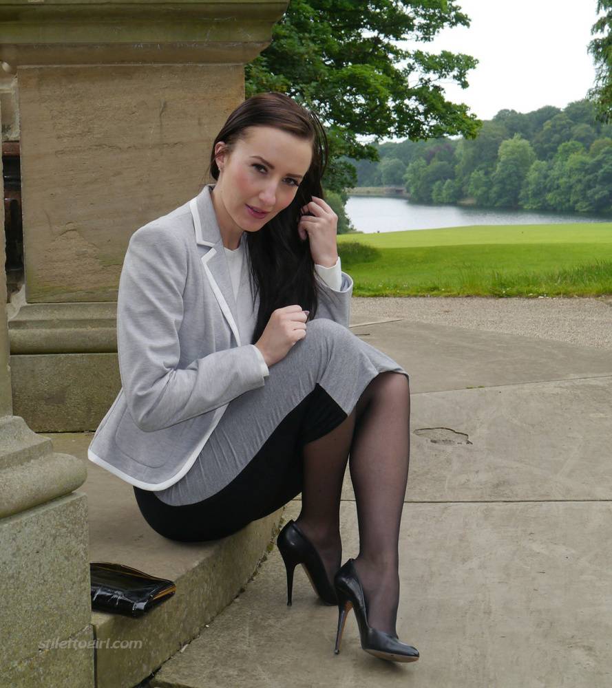 Clothed woman Sophia descends park steps in a long skirt and stiletto heels | Photo: 1286573