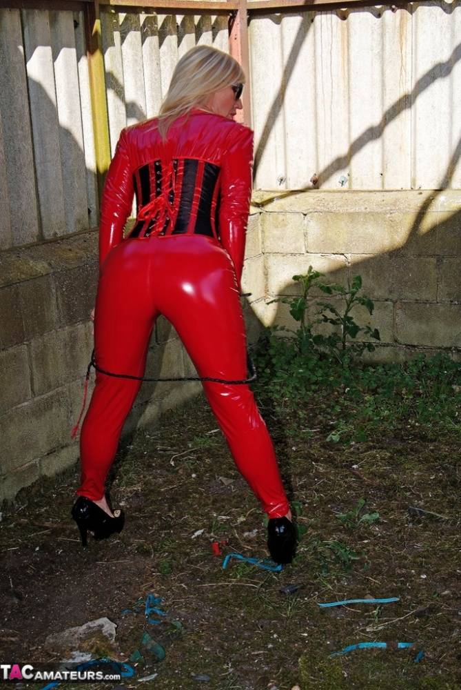 Hot older blonde Melody displays her big tits in red latex clothing and shades - #13