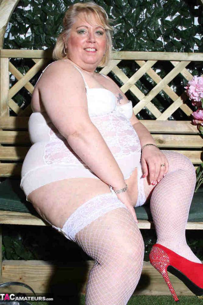 Fat blonde Lexie Cummings dildos her pierced pussy in a garden setting | Photo: 1484358
