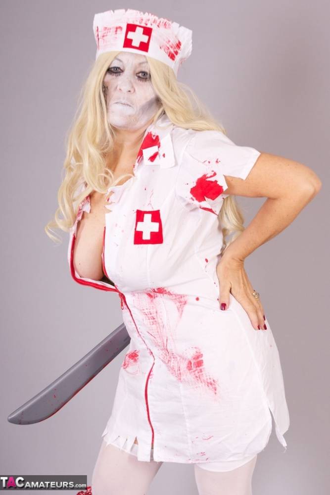 Old blonde amateur Savana removes a nurse uniform during a cosplay scene - #11