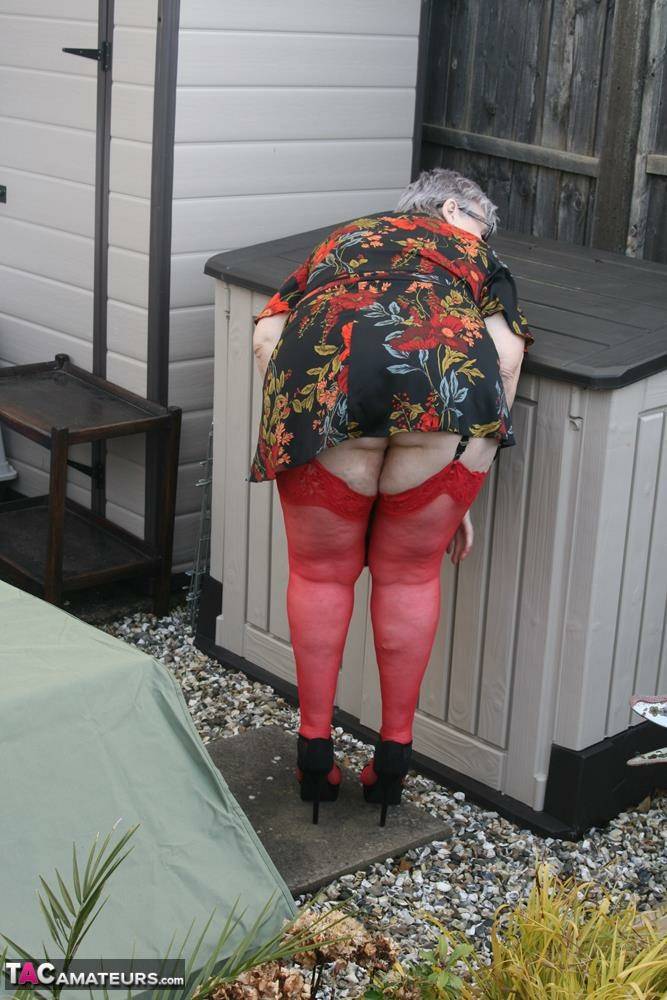 Naughty granny shows her tits and twat in backyard wearing red stockings - #1