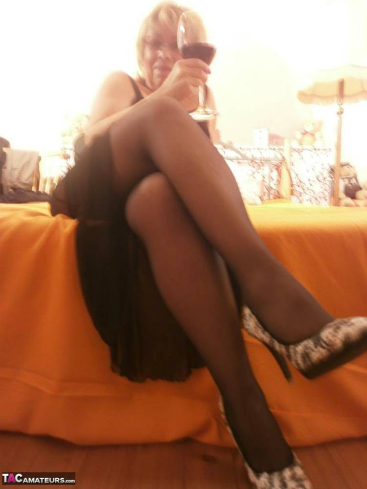 Tipsy hot granny Caro spreading legs on the bed wearing black stockings - #11