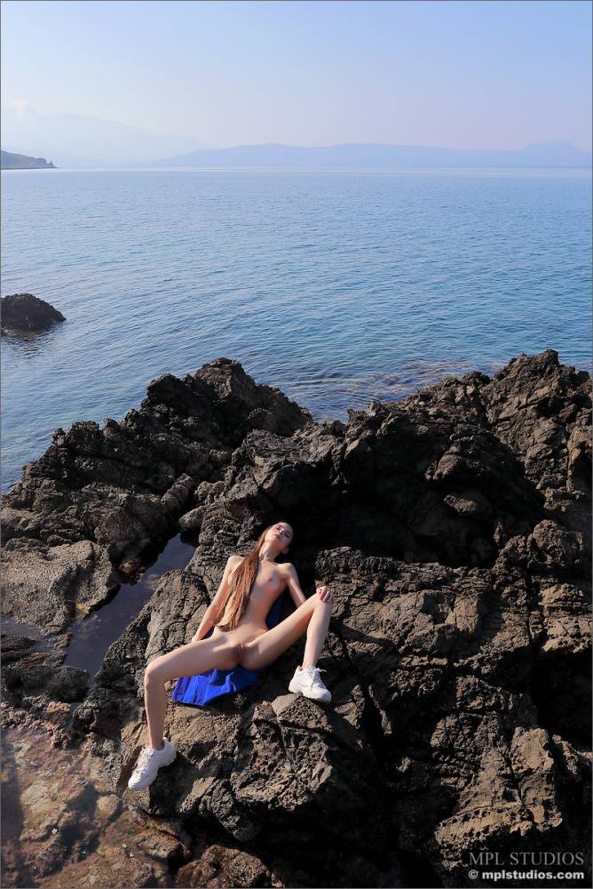 Long legged beauty gets naked in white runners on oceanside rocks - #12