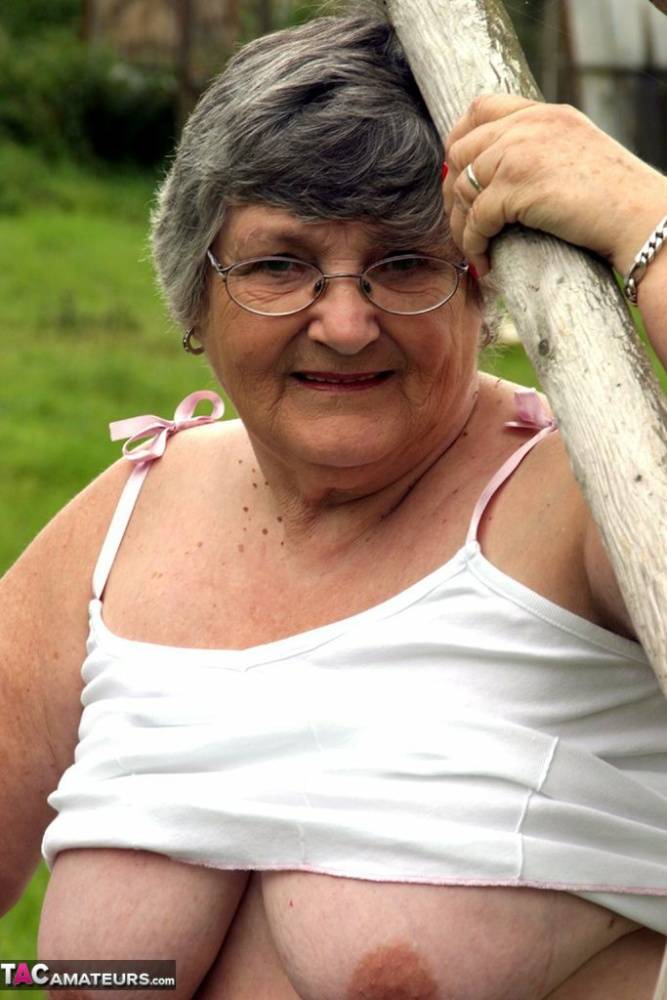 Old British woman Grandma Libby exposes her boobs on a backyard bench swing | Photo: 1585353