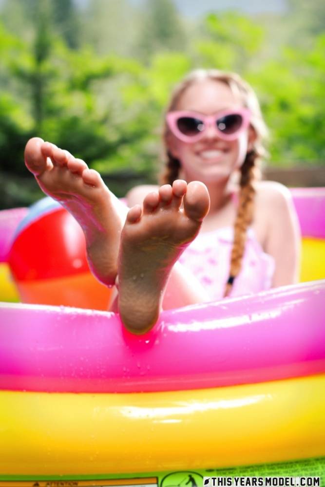 Adorable teen Dolly Little tugs on her braided pigtails in a blowup pool - #8