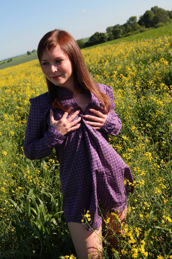 Young redhead gets completely naked in a field of Rapeseed - #2