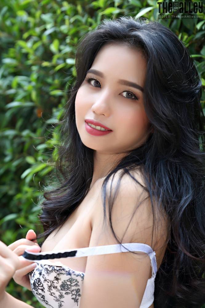 Beautiful Asian girl Norah gets totally naked next to a hedge in a garden - #10