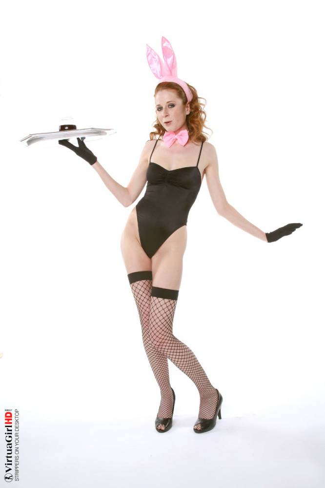 Natural redhead Lucie T holds a drink tray while stripping to fishnets | Photo: 82629
