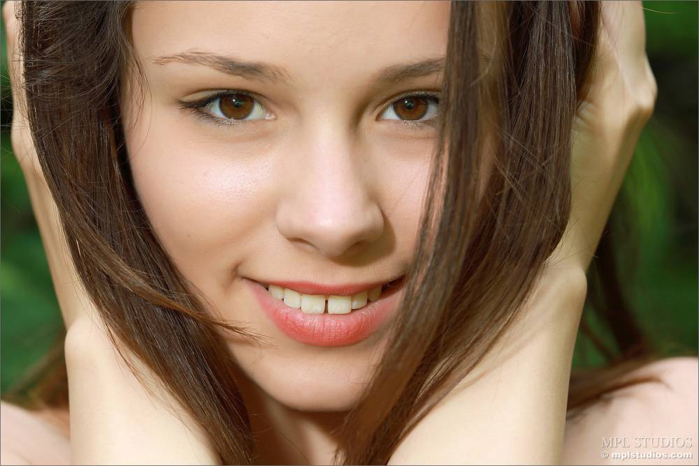 Charming young girl with a pretty face models bare naked near trees | Photo: 97072