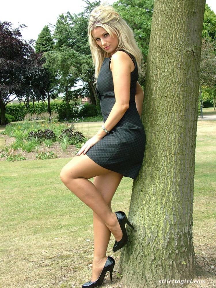 Hot blonde shows off her great legs in a black dress and stiletto heels | Photo: 98351