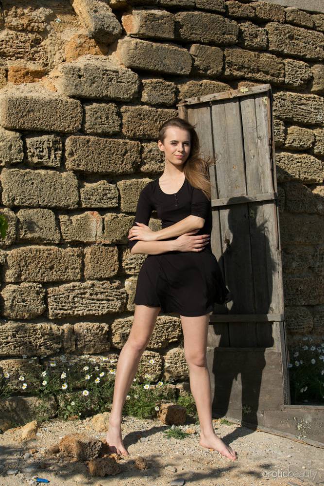 Caucasian teen Gracie removes a black dress to pose nude by a root cellar door | Photo: 103931