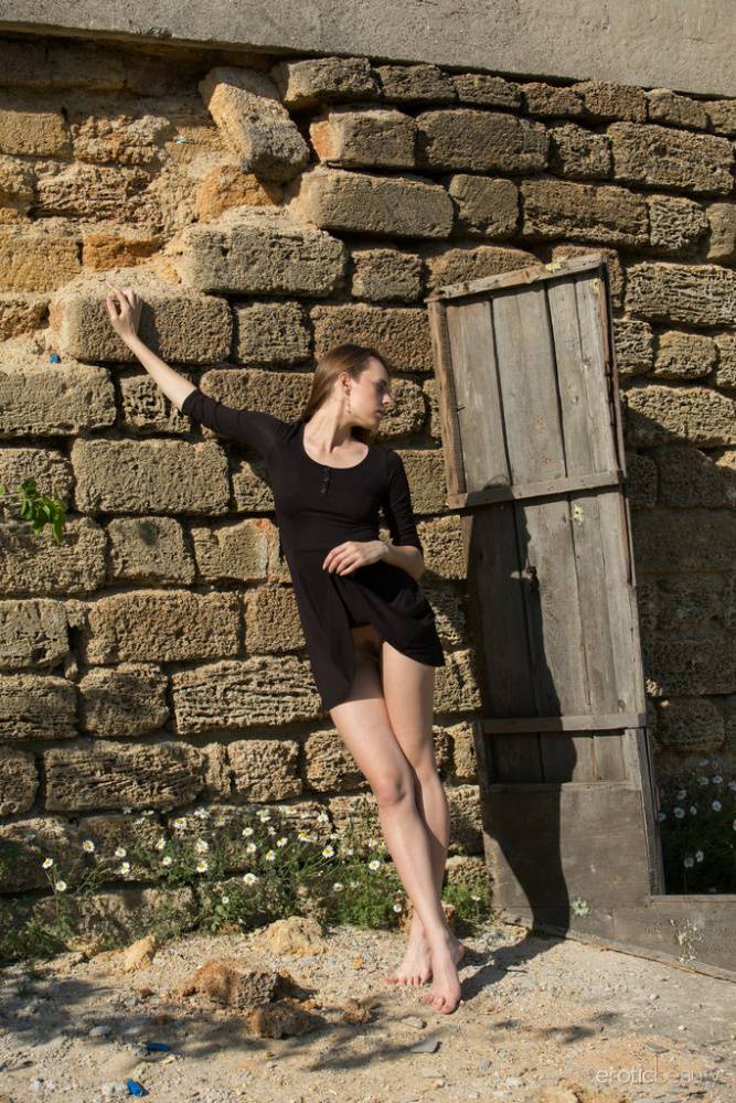 Caucasian teen Gracie removes a black dress to pose nude by a root cellar door | Photo: 103898