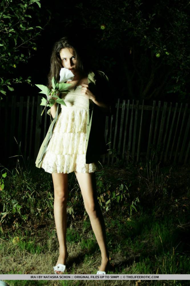 Brunette teen Ira I gets naked in a backyard at night while holding a flower - #8