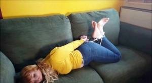 Barefoot white girl is hogtied on a sofa while ball gagged in her clothing - #main
