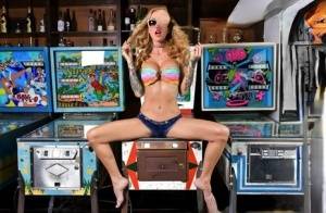 Inked chick Sarah Jessie toys her pussy atop a pinball machine while alone | Photo: 91014