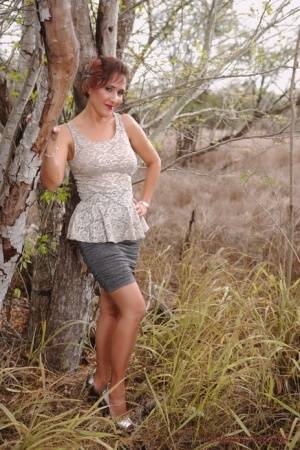 Mature pinup model Roni Ford kicks off pumps wearing retro lingerie in woods on galphoto.com