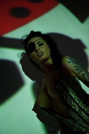 Solo girl Christy Mack wears an eye patch and lingerie while posing in shadows on galphoto.com
