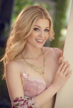 Beautiful blonde Charlotte Stokely uncovers tiny tits before petting her pussy on galphoto.com