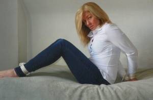 Blonde woman is cleave gagged and hogtied in a white blouse and blue jeans on galphoto.com