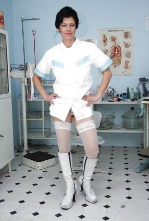 Seductive mature nurse in white stockings playing with a huge dildo on galphoto.com