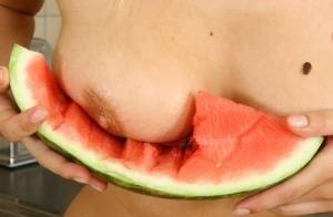 Blonde vixen Flower undressing in the kitchen to eat melon with bare big tits on www.galphoto.com