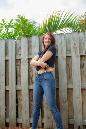 Hot redhead Andy Adams loses her t-shirt & jeans in the yard to pose naked on galphoto.com