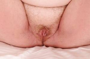 Mature plumper with huge saggy jugs and hairy cooter posing on the bed on galphoto.com