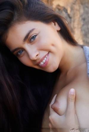Sweet teen Foxy Alissa removes her sweater to pose nude near a stone wall on www.galphoto.com
