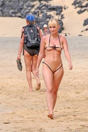 Hot blonde removes a skimpy bikini during a visit to a public beach on galphoto.com