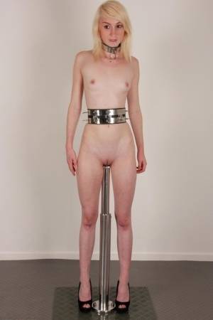 Skinny blonde teen Noa sports a collar while impaled on a dildo post on galphoto.com