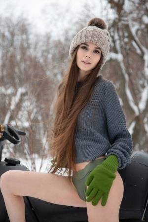Teen model Leona Mia shows her tits and twat atop a snowmobile in the winter on galphoto.com